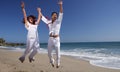 Young Couple at the beach jumping for joy Royalty Free Stock Photo