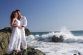 Young couple at the beach standing on rocks