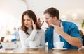 Young couple beautiful woman and handsome man quarrelling, having argument while drinking coffee in cafe during lunch time break, Royalty Free Stock Photo