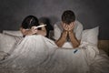 Young couple in bed scared and stressed after positive result on pregnancy test with pregnant woman expecting unwanted baby and ma Royalty Free Stock Photo