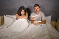 Young couple in bed scared and stressed after positive result on pregnancy test with pregnant woman expecting unwanted baby and ma Royalty Free Stock Photo