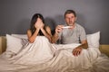 Young couple in bed scared and stressed after positive result on pregnancy test with pregnant woman expecting unwanted baby and ma Royalty Free Stock Photo