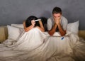 Young couple in bed scared and stressed after positive result on pregnancy test with pregnant woman expecting unwanted baby and ma Royalty Free Stock Photo