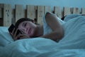 Young couple in bed using mobile phone lying backs to each other, relationship and communication problems