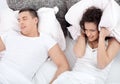 Young couple in bed woman trying to sleep while a man is snoring Royalty Free Stock Photo