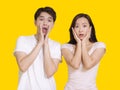 Young couple being amazed.Isolated on yellow background