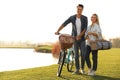 Young couple with bicycle and picnic basket near lake Royalty Free Stock Photo