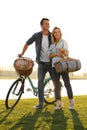 Young couple with bicycle and picnic basket near lake Royalty Free Stock Photo