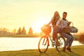 Young couple with bicycle and picnic basket near lake Royalty Free Stock Photo