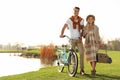 Young couple with bicycle and picnic basket near lake Royalty Free Stock Photo