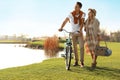 Young couple with bicycle and picnic basket near lake Royalty Free Stock Photo
