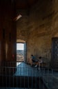 A young couple bored, looking at their cell phone, sitting on a bench in the tower of the Church of La Clerecia. View of Salamanca