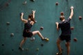 young couple bouldering on rock climbing wall at indoor gym Royalty Free Stock Photo