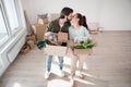 Young couple with boxes kissing when moving in new flat, new home and relocation concept.