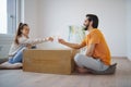 Young couple with boxes and wine moving in new flat, new home and relocation concept.