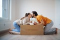 Young couple with boxes and wine moving in new flat, new home and relocation concept.