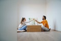 Young couple with boxes and wine moving in new flat, new home and relocation concept.