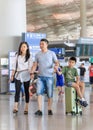 Young couple with boy on suitcase at Beijing Capital International Airport