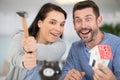 young couple breaking piggy bank with hammer at home Royalty Free Stock Photo