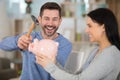 young couple breaking piggy bank with hammer at home Royalty Free Stock Photo