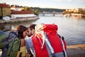 Young couple on bridge at Prague kissing at sunset