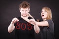 Young couple with broken heart and sos word. Royalty Free Stock Photo