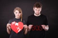 Young couple with broken heart and sos word Royalty Free Stock Photo