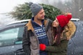 Couple with their Christmas tree on roof of the car Royalty Free Stock Photo