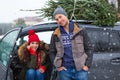 Couple with their Christmas tree on roof of the car Royalty Free Stock Photo