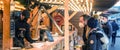 Young couple buying delicious CHristmas Market alsatian food at market stall