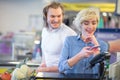 Woman at the supermarket checkout, she is paying using a credit card Royalty Free Stock Photo