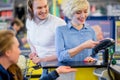 Woman at the supermarket checkout, she is paying using a credit card.