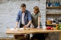 Young couple caking pizza in kitchen together