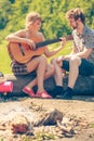 Young couple camping playing guitar outdoor Royalty Free Stock Photo