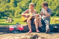 Young couple camping playing guitar outdoor Royalty Free Stock Photo