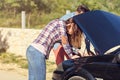 Young couple after a car breakdown at the side of the road Royalty Free Stock Photo