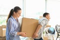 Young couple carrying box indoors. Moving into new house Royalty Free Stock Photo
