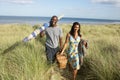 Young Couple Carrying Picnic Basket And Windbreak Royalty Free Stock Photo