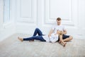Young couple in casual clothes sitting on floor and talking Royalty Free Stock Photo