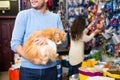 Young couple with cat in petshop