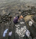 A young couple catches and cleans the fish caught by the sea on the rocks of Playa Blanca, Lanzarote, Spain