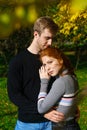 young couple are standing in an embrace in the park on a sunny day Royalty Free Stock Photo