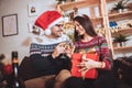 Couple celebrating Christmas at home opens gift Royalty Free Stock Photo