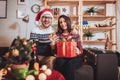 Couple celebrating Christmas at home opens gift Royalty Free Stock Photo