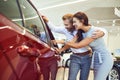Young couple choose a new car in showroom. Royalty Free Stock Photo