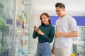 a young couple chooses mobile phone accessories products on a glass display case