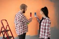 Young couple choosing color for painting home standing near wall in apartment. Repair, interior design, building Royalty Free Stock Photo