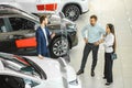 Young couple choosing new car in showroom. service, selling Royalty Free Stock Photo