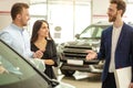 Young couple choosing new car in showroom. service, selling Royalty Free Stock Photo