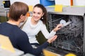 Young couple choosing new dish washing machine in supermarket Royalty Free Stock Photo